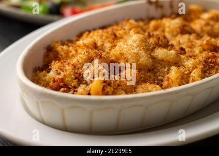 Casserole or lasagna sprinkled with breadcrumbs in white oval ceramic baking dish Stock Photo