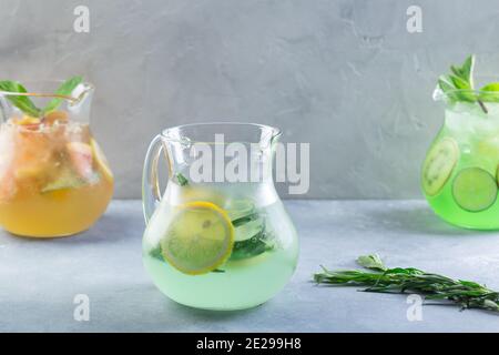 Different color lemonade in glass decanters with fruits and fresh mint Stock Photo