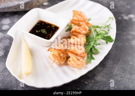 Grilled salmon skewers served with lemon and sauce. Top view Stock Photo