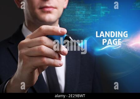 Business, Technology, Internet and network concept. Young businessman working on a virtual screen of the future and sees the inscription: Landing page Stock Photo