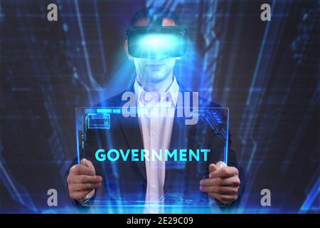 Business, Technology, Internet and network concept. Young businessman working in virtual reality glasses sees the inscription: Government Stock Photo