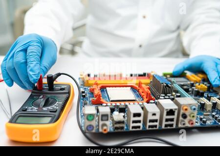 Multimeter with main board, maintenance, repairing and checking computer hardware concept. Stock Photo