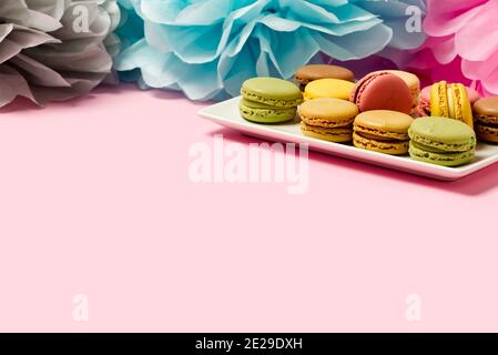 Colorful macarons on the plate on pink background with copy space Stock Photo
