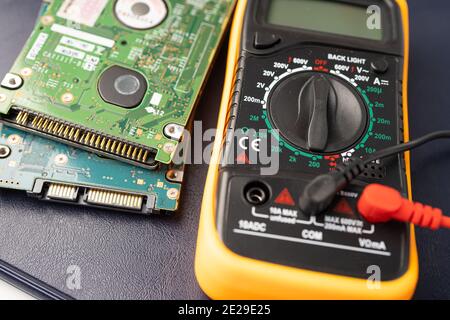 Multimeter with main board, maintenance, repairing and checking computer hardware concept. Stock Photo