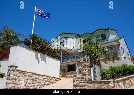 Sydney coastal detached home in Avalon Beach with lush garden and australian flag flying on flagpole,Sydney,Australia Stock Photo