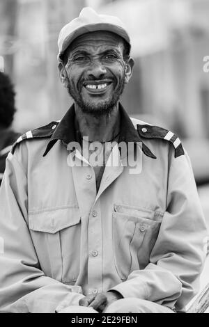 ADDIS ABABA, ETHIOPIA - Jan 05, 2021: Addis Ababa, Ethiopia, January 27, 2014, Happy African man sitting on street corning smiling straight into the c Stock Photo