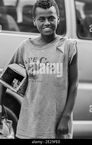 ADDIS ABABA, ETHIOPIA - Jan 05, 2021: Addis Ababa, Ethiopia, January 27, 2014, Young teenager working as a shoe shine boy on the street, looking strai Stock Photo