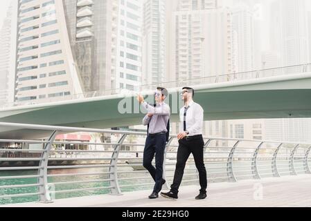 Business people on move. Two young successful architects in Dubai Marine walking and looking at their new business locations. Stock Photo