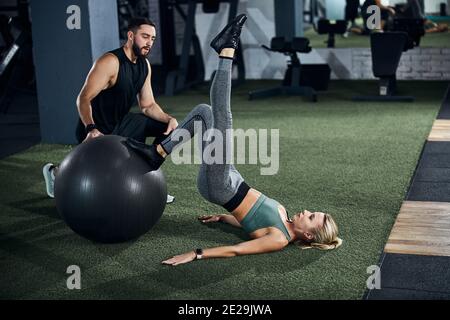 Leg stretching under the direction of a trainer Stock Photo