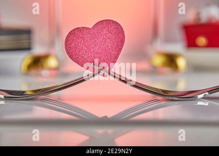 Valentine's Day or romantic birthday dinner with candy hearts, champagne glasses and elegant table setting with reflection Stock Photo