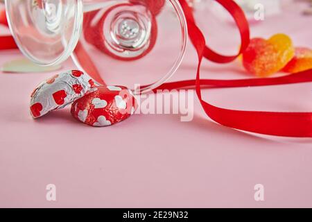 Valentine's day greeting card with glasses of champagne and candy hearts on pink background Stock Photo