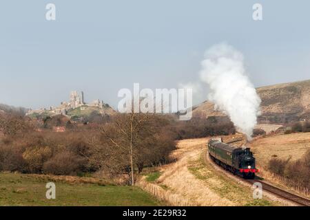 CORFE, DORSET, UK - MARCH 20, 2009:  Steam train on the Swanage Railway Heritage Line steams past Corfe castle