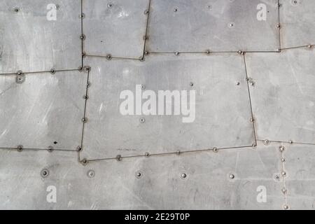 Aluminum aircraft skin. Riveted metal background. High resolution image of old silver stainless steel aluminum surface texture with rivets and seams Stock Photo