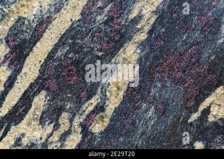 Grey granite background. High resolution image of stone granite texture with red purple veins spots. Stock Photo