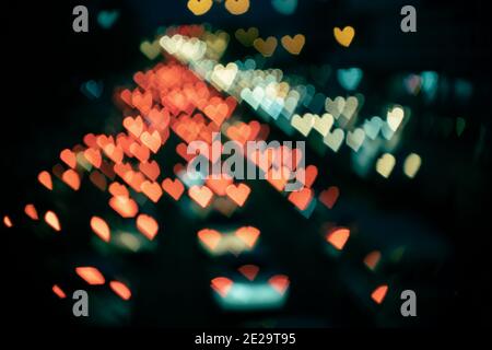 Blurry abstract heart-shaped bokeh from cars in film look Stock Photo
