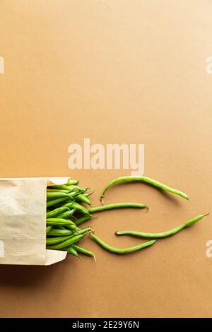 Green beans or kidney beans in a craft bag on a brown background. Harvest organic healthy food Stock Photo