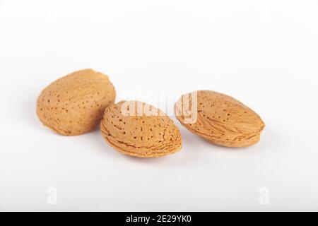 Three almond nuts in their shells Stock Photo