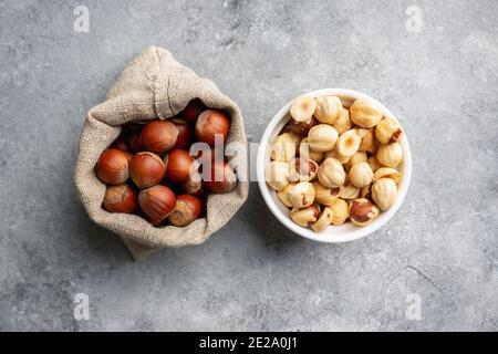 Hazelnuts peeled and in shell on gray background. Background and textures. Stock Photo