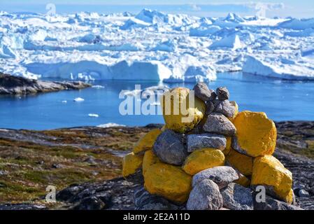 Ilulissat, Greenland, July - mile marker on a hiking trail in the Disko Bay - beautiful landcape with big icebergs in the Baffin bay - Ilulissat icefj Stock Photo