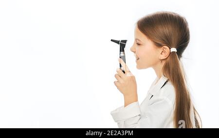 Positive girl in white medical uniform holding ophthalmoscope, isolated on white Stock Photo