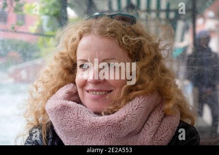 Portrait of a beautiful mature woman with red curly hair on vacation in Venice, italy Stock Photo
