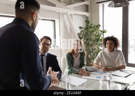 Confident male CEO lead meeting with diverse colleagues Stock Photo