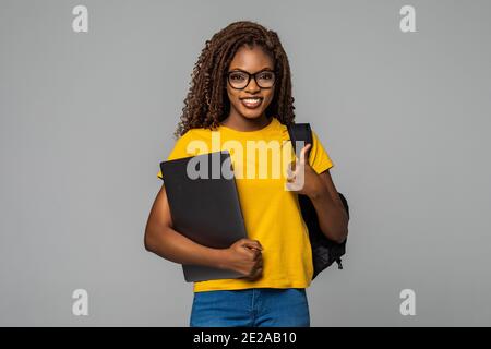 education series template - Friendly ethnic black woman high school student typing on portable computer Stock Photo