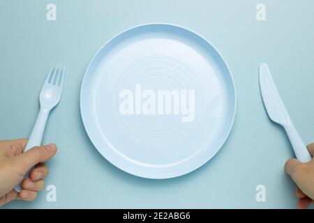 Fork, knife and empty plate on sky blue background. flat lay, top view, copy space Stock Photo