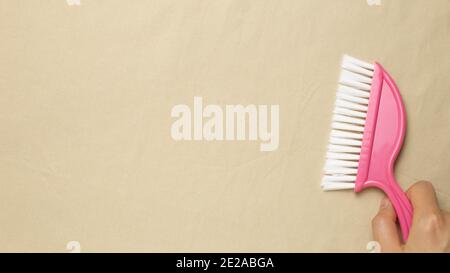Cleaning housework concept. Pink broom on beige fabric background. flat lay, top view, copy space Stock Photo