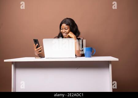a young lady using her phone in her office Stock Photo