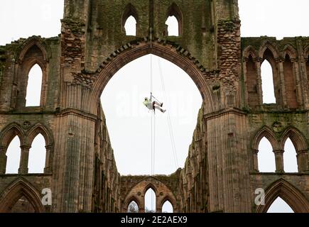 Stonemason James Preston from SSH Conservation, abseils from Rievaulx Abbey in North Yorkshire as English Heritage prepares to carry out vital conservation work. English Heritage commissions a survey at Rievaulx Abbey on a five year cycle to assess the condition of the abbey from ground level right to the top of the structure. Stock Photo