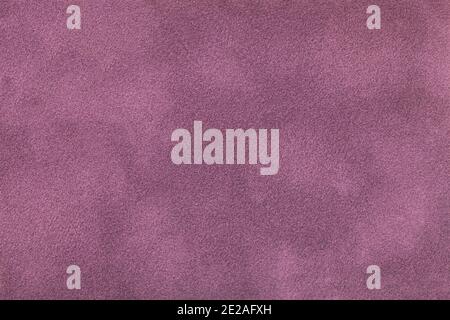 Dark purple matte background of suede fabric, closeup. Velvet texture of seamless lilac textile, macro. Structure of violet felt canvas backdrop. Stock Photo