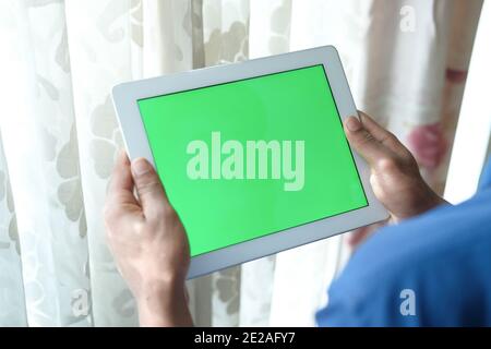 rear view of young man using digital tablet at home  Stock Photo