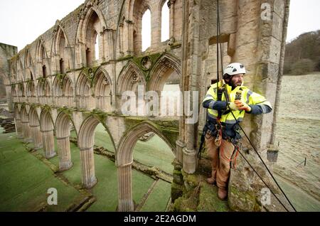 Stonemason James Preston from SSH Conservation, surveys Rievaulx Abbey in North Yorkshire as English Heritage prepares to carry out vital conservation work. English Heritage commissions a survey at Rievaulx Abbey on a five year cycle to assess the condition of the abbey from ground level right to the top of the structure. Stock Photo