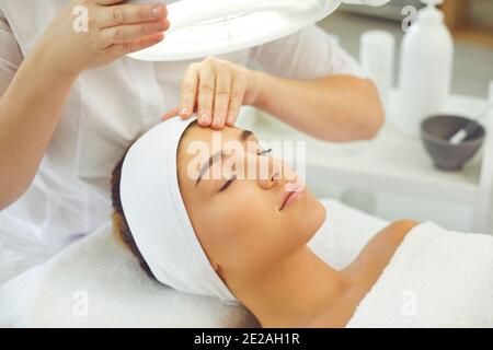 Good-looking young woman enjoying professional beauty procedures in modern salon Stock Photo