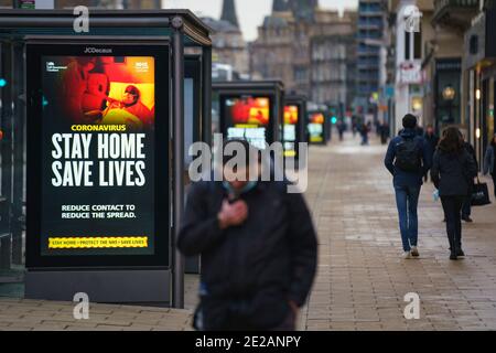 Edinburgh, Scotland, UK. 13 January 2021. Views of virtually empty Princes Street in Edinburgh with Covid-19 health warning displays on bus shelters. Almost all shops have ceased click and collect services so very few shoppers are out during lockdown. Iain Masterton/Alamy Live News Stock Photo