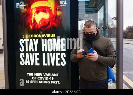 Edinburgh, Scotland, UK. 13 January 2021. Views of virtually empty Princes Street in Edinburgh with Covid-19 health warning displays on bus shelters. Almost all shops have ceased click and collect services so very few shoppers are out during lockdown. Iain Masterton/Alamy Live News Stock Photo