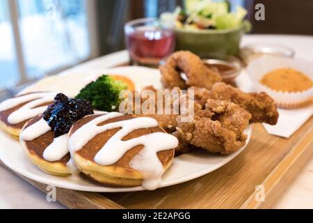 Classic USA breakfast. fried chicken, pancakes waffles, fried eggs. Stock Photo