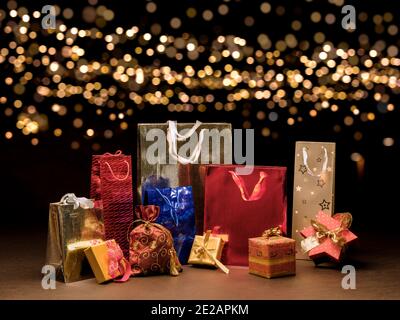 Shopping bag in red, blue, silver, with packages covered with gold-colored gift paper. Sale concept. Idea of gifts, offers, sales, events. Stock Photo