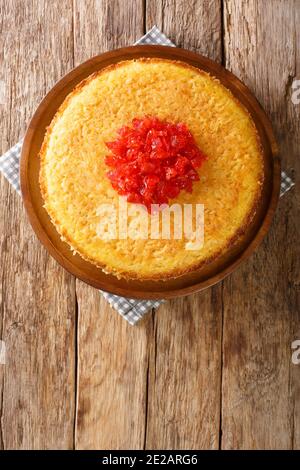 Tasty tahchin, a Persian dish of a baked rice, chicken, and yogurt colored by saffron closeup in the plate on the table. Vertical top view from above Stock Photo