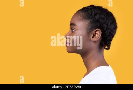 Profile Portrait Of Black Young Lady Posing Over Yellow Background Stock Photo