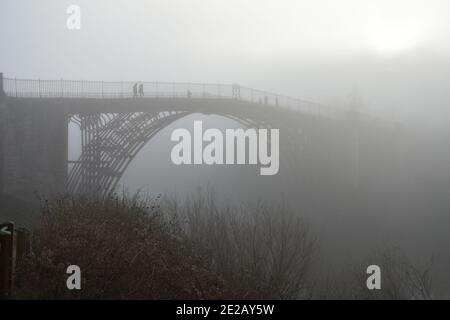 The Ironbridge, Shropshire, UK on a misty morning spanning the river severn.  The bridge is enveloped in fog giving an eeriness on a winter day Stock Photo