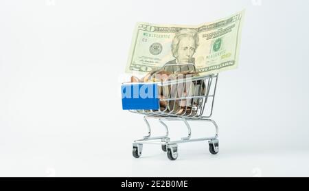 Money and financial concept.Shopping cart full of coins with a twenty dollars american banknote.Shopping online, E-commerce, business marketing isolat Stock Photo