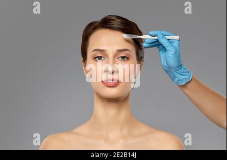 beautiful young woman and hand with scalpel Stock Photo