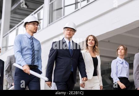 business team in helmets walking along office Stock Photo
