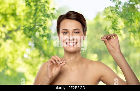 happy young woman with dental floss cleaning teeth Stock Photo