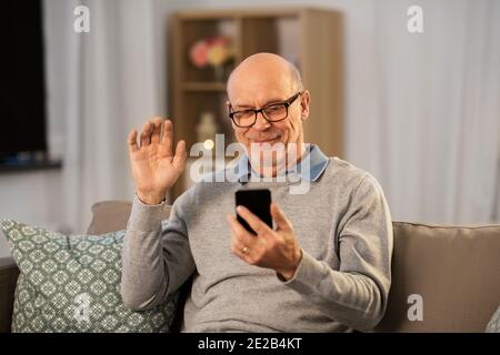 old man with smartphone having video call at home Stock Photo