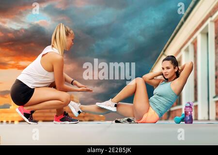 women training and doing bicycle crunches outdoors Stock Photo