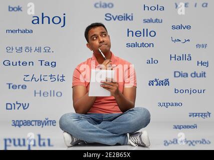 indian man in polo shirt with notebook and pen Stock Photo