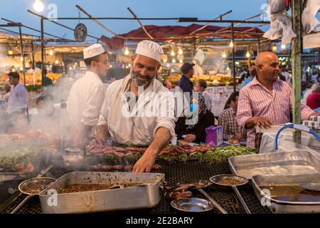 A cook at a food stall in Jemaa el-Fnaa, the main square of Marrakesh, Morocco. Street food stalls in Marrakech’s Djemaa el Fna square Stock Photo
